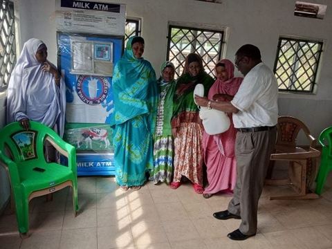 Women from a camel milk enterprise beside a milk dispensing machine supported under TWENDE