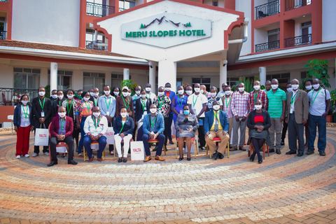 A large group of participants posing for a photo outside the Meru Slopes Hotel