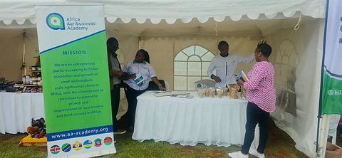 Visitors at the AAA exhibition stand at the Sokoni Agribusiness Expo, beside an AAA mission banner